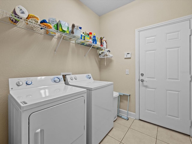 washroom with light tile patterned floors and washing machine and clothes dryer