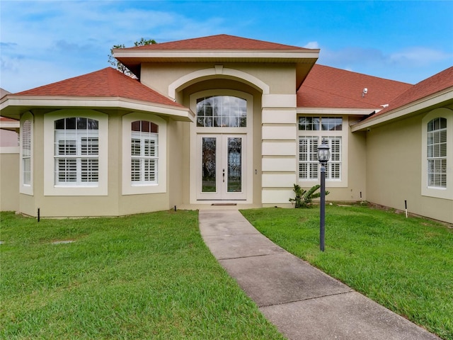 entrance to property with a yard and french doors