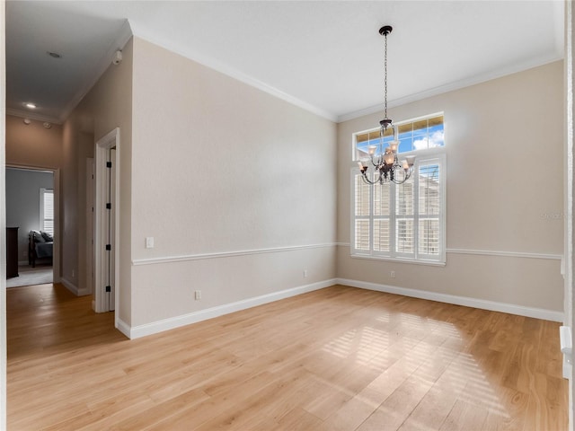 spare room with crown molding, light hardwood / wood-style floors, and a notable chandelier