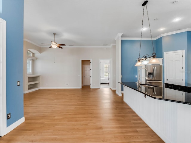 kitchen featuring a wealth of natural light, sink, pendant lighting, and light hardwood / wood-style floors