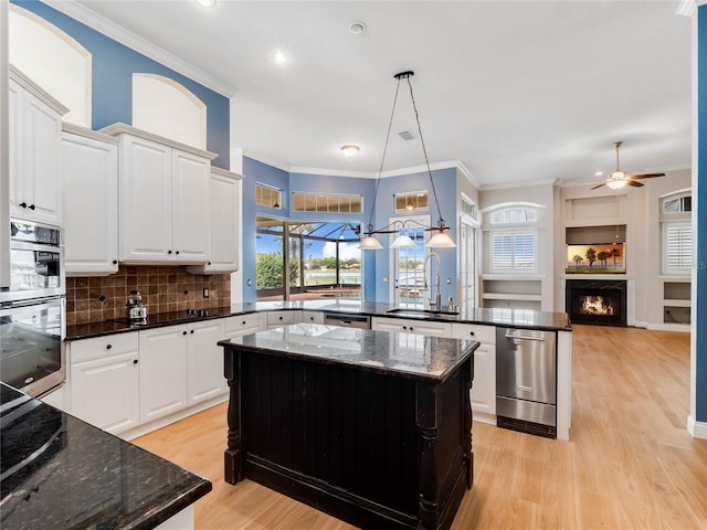 kitchen featuring sink, white cabinets, hanging light fixtures, and plenty of natural light