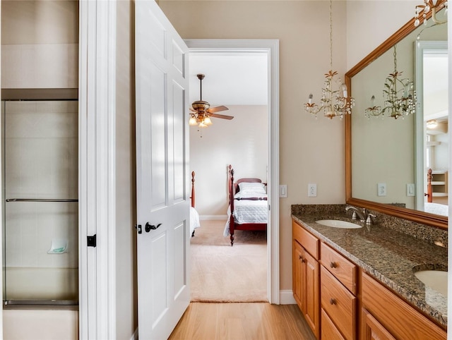 bathroom with hardwood / wood-style floors, ceiling fan, an enclosed shower, and vanity