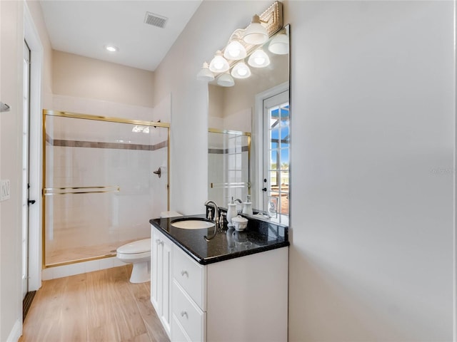 bathroom with vanity, toilet, wood-type flooring, and walk in shower