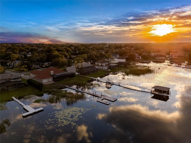 aerial view at dusk featuring a water view