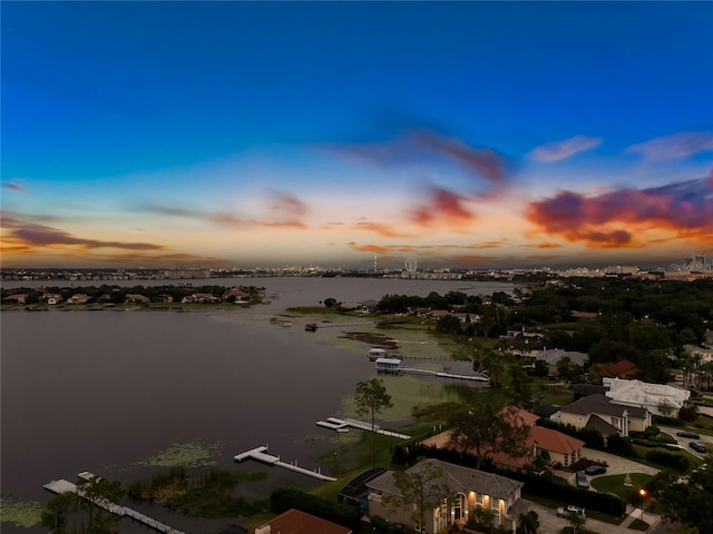 aerial view at dusk featuring a water view