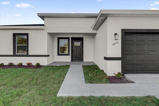 entrance to property with a garage and a yard