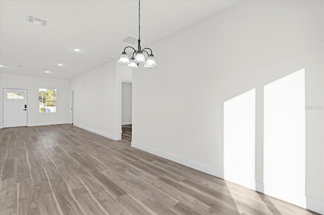 interior space featuring an inviting chandelier and light hardwood / wood-style flooring