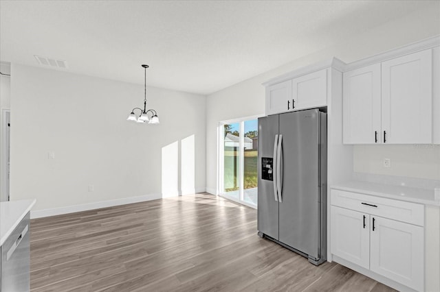 kitchen featuring white cabinetry, light hardwood / wood-style floors, hanging light fixtures, stainless steel refrigerator with ice dispenser, and a notable chandelier