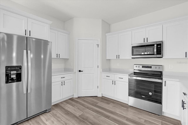 kitchen featuring stainless steel appliances, light wood-type flooring, and white cabinetry