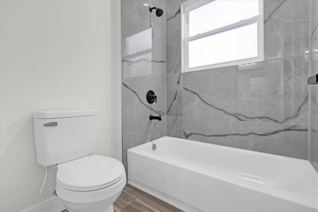 bathroom featuring toilet, tiled shower / bath combo, and wood-type flooring