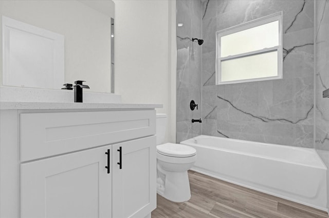 full bathroom with toilet, vanity, hardwood / wood-style floors, and tiled shower / bath