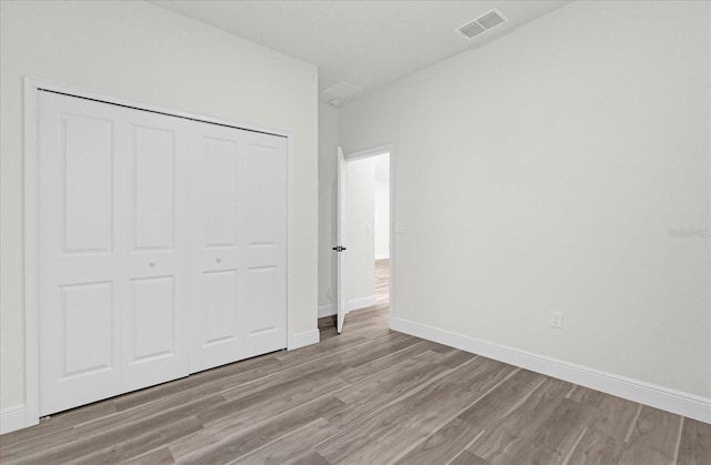 unfurnished bedroom with a closet and light hardwood / wood-style floors