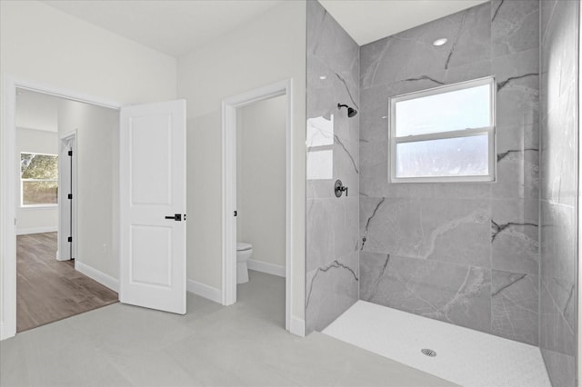 bathroom featuring toilet and a tile shower