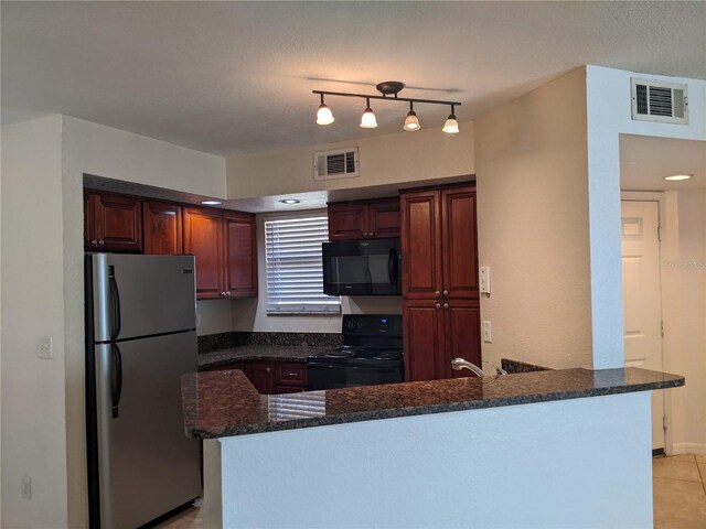 kitchen featuring black appliances, kitchen peninsula, light tile patterned floors, and dark stone counters