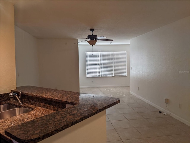 kitchen with ceiling fan, kitchen peninsula, sink, and light tile patterned floors