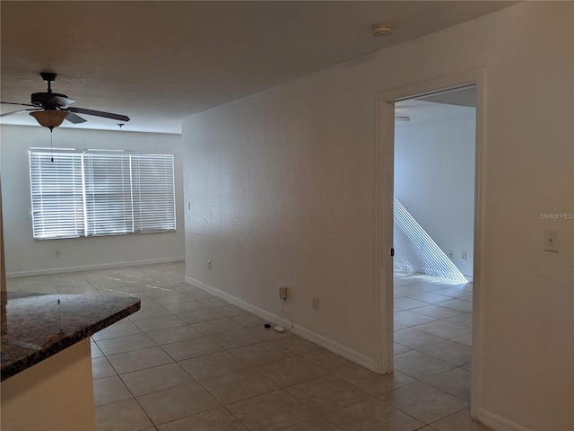 empty room featuring light tile patterned floors and ceiling fan