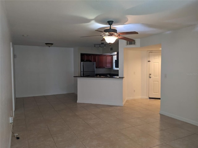 kitchen featuring kitchen peninsula, stainless steel refrigerator, ceiling fan, and light tile patterned flooring