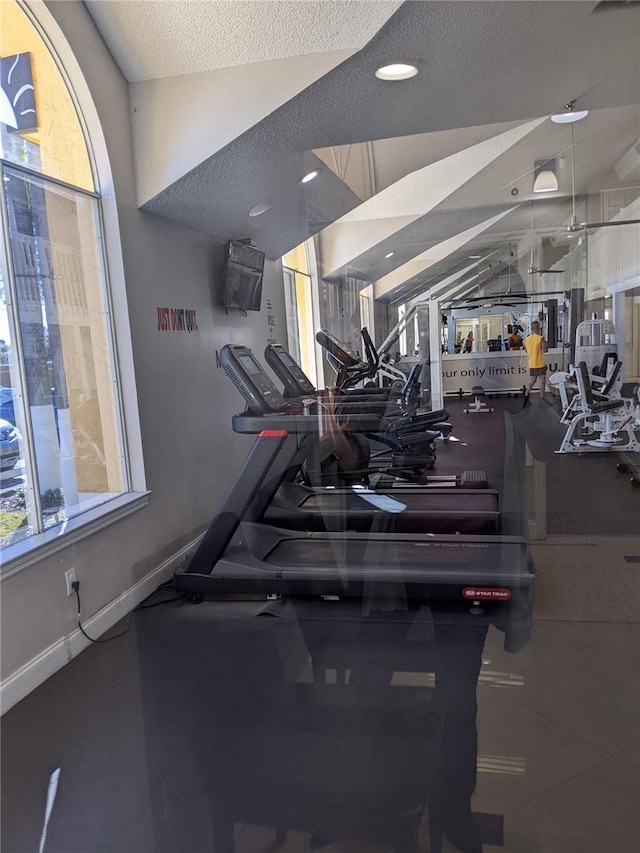 gym featuring a textured ceiling and vaulted ceiling