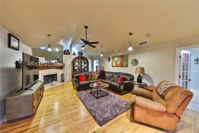 living room with lofted ceiling, ceiling fan, and light wood-type flooring