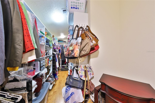 walk in closet with hardwood / wood-style flooring