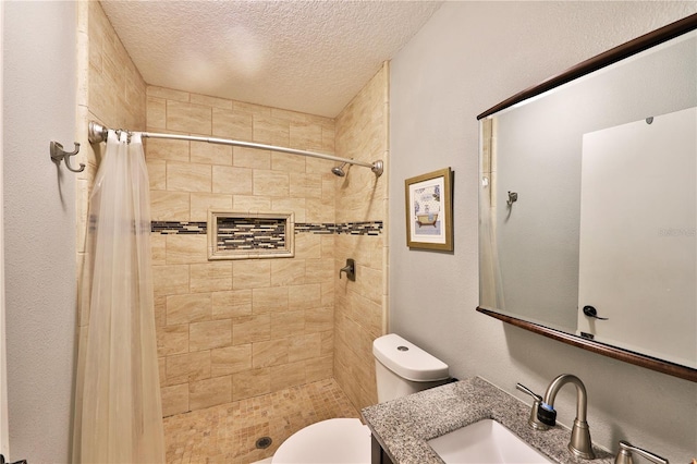 bathroom featuring curtained shower, vanity, a textured ceiling, and toilet