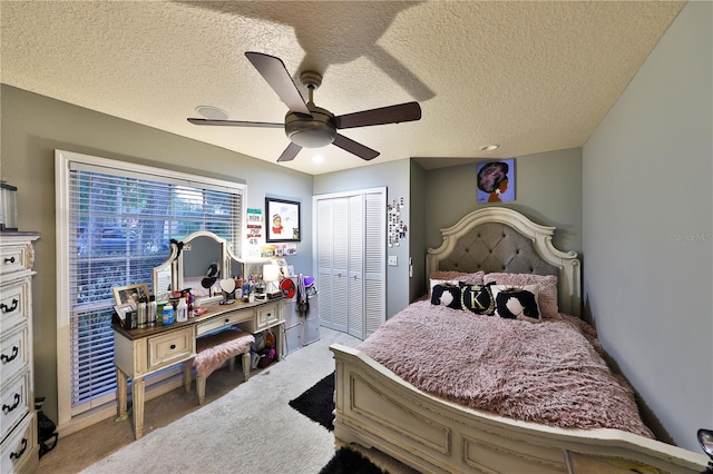 bedroom featuring ceiling fan, light colored carpet, a textured ceiling, and a closet