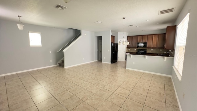 kitchen featuring black appliances, sink, decorative backsplash, decorative light fixtures, and light tile patterned flooring