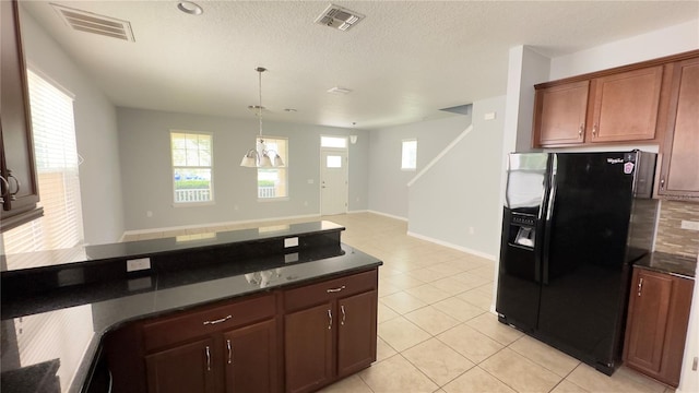 kitchen featuring pendant lighting, a textured ceiling, black refrigerator with ice dispenser, and light tile patterned flooring