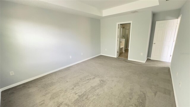 unfurnished bedroom featuring dark colored carpet and ensuite bath