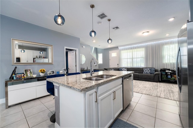 kitchen with white cabinets, appliances with stainless steel finishes, decorative light fixtures, and sink