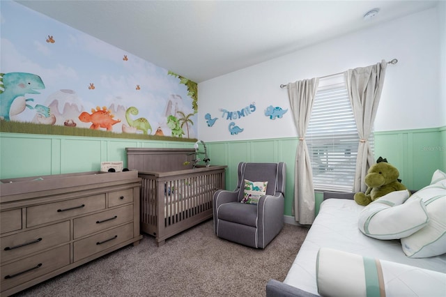 carpeted bedroom featuring a nursery area