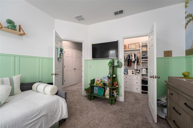 carpeted bedroom featuring a spacious closet and a closet