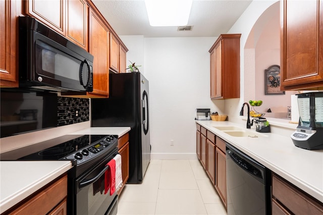 kitchen with light tile patterned floors, sink, and black appliances