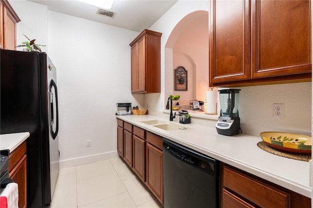 kitchen featuring sink, light tile patterned flooring, and black appliances