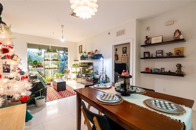 tiled dining room featuring a chandelier