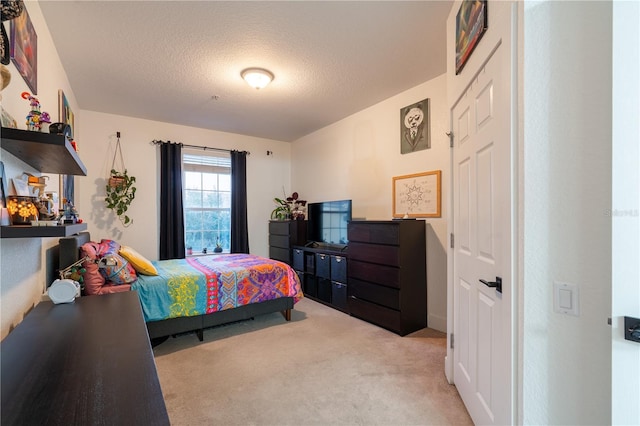 bedroom with light carpet and a textured ceiling