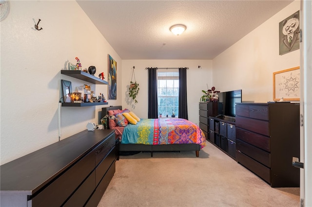 bedroom with light carpet and a textured ceiling