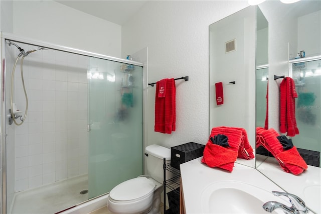 bathroom featuring sink, a shower with door, and toilet