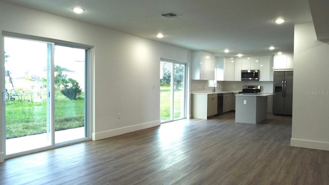 kitchen featuring white cabinets, a center island, dark hardwood / wood-style flooring, and appliances with stainless steel finishes