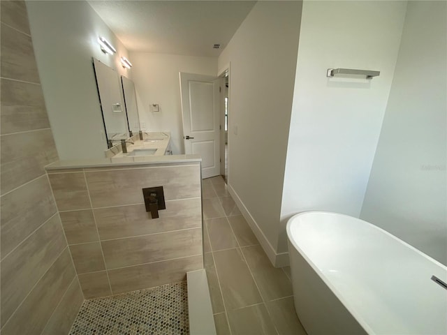 bathroom with tile patterned floors, vanity, and a bath