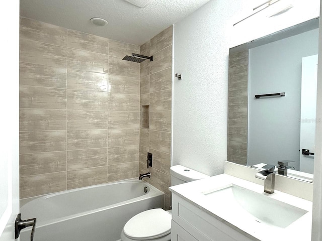 full bathroom featuring toilet, vanity, a textured ceiling, and tiled shower / bath combo