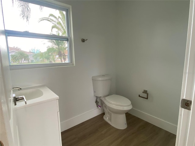 bathroom with hardwood / wood-style floors, vanity, and toilet