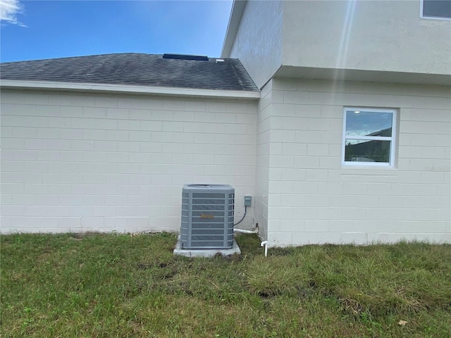 view of property exterior with a lawn and cooling unit