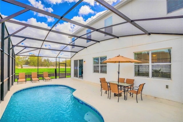 view of pool with glass enclosure and a patio area