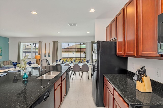 kitchen featuring dark stone counters, sink, and a healthy amount of sunlight