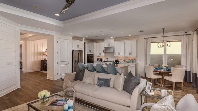 851 Arbor Green Trl, Saint Cloud, FL 34771 - living room featuring dark wood-style floors, ornamental molding, and a chandelier