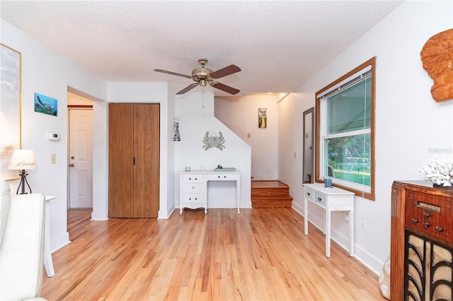 bedroom with a closet, a textured ceiling, ceiling fan, and light hardwood / wood-style flooring