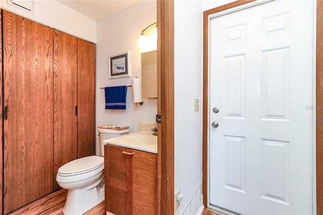 bathroom featuring vanity, hardwood / wood-style floors, and toilet