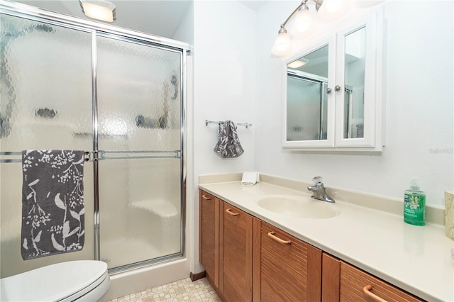 bathroom featuring vanity, toilet, and a shower with door