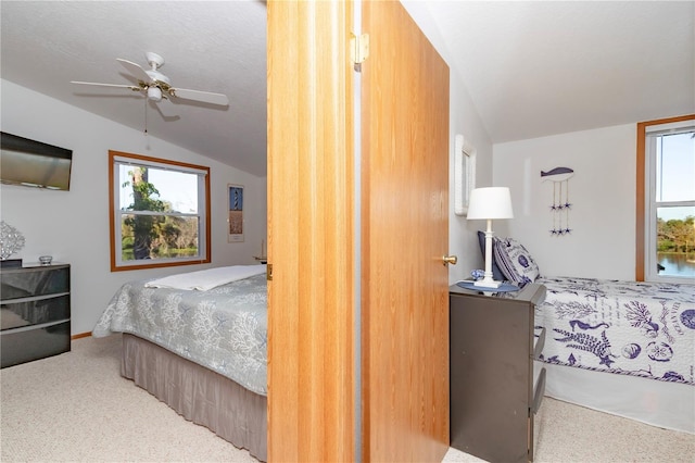 bedroom featuring vaulted ceiling, light carpet, and ceiling fan